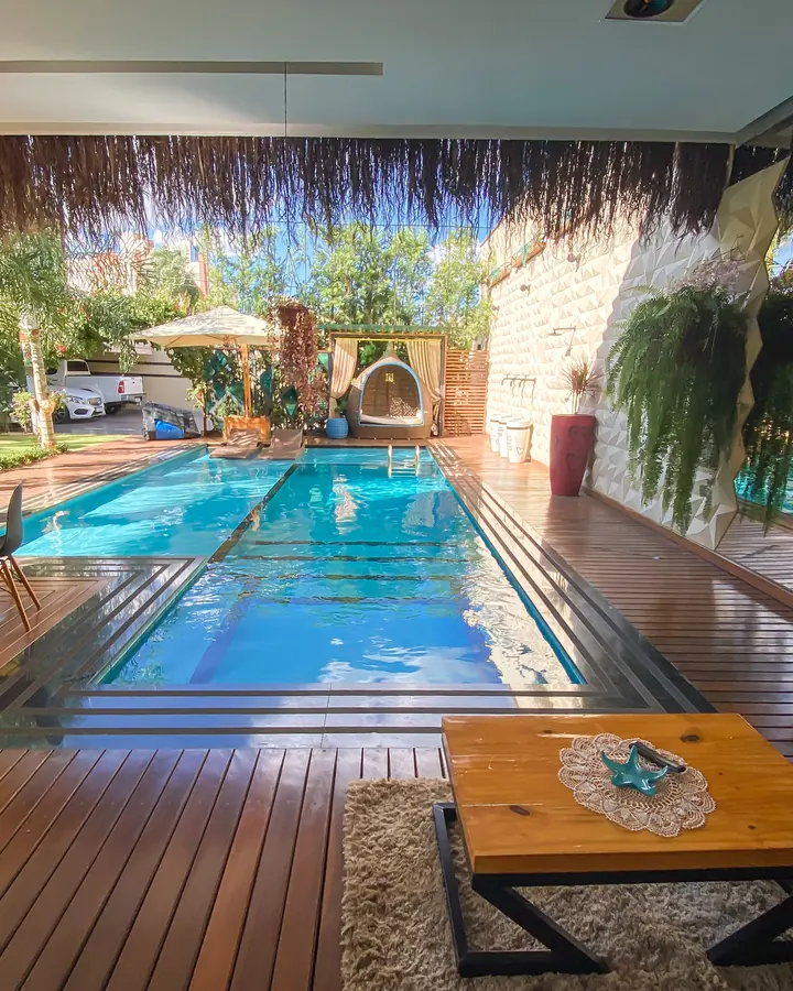 Deck de madeira instalado ao redor de piscina em área de lazer